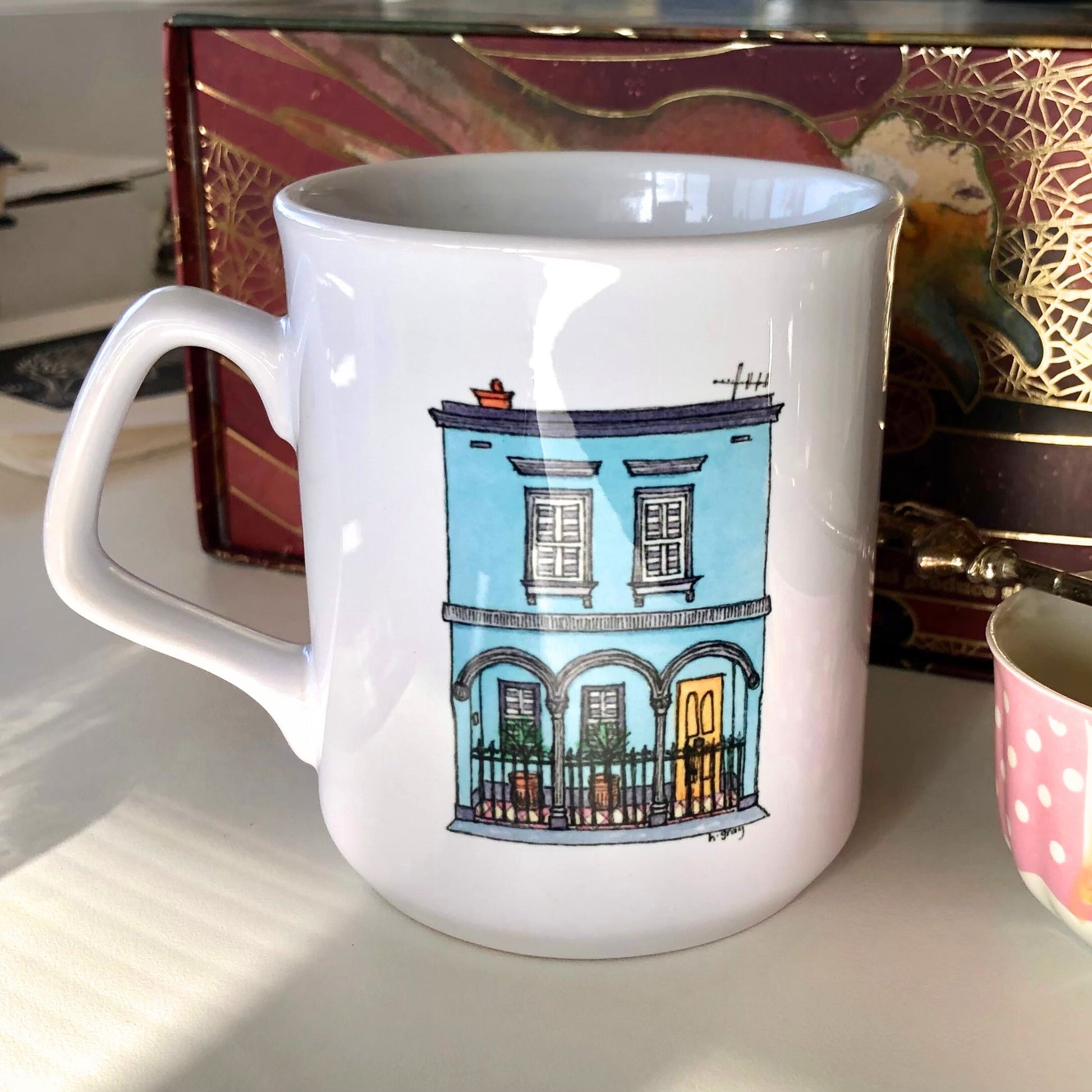 White coffee mug showing a watercoloured, aqua blue, Australian, Victorian era terrace house.  From original artwork.