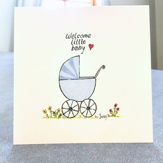 Square baby card, with an old fashioned blue pram with some flowers on the ground.