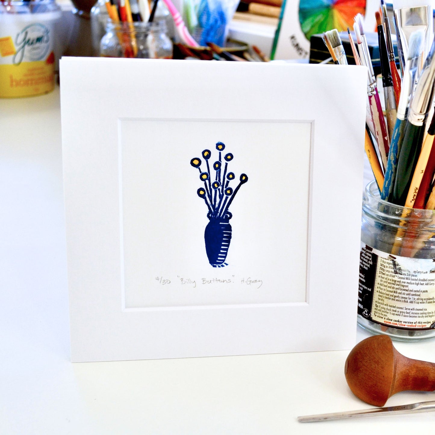 Yellow Billy Buttons in a small vase printed in Prussian Blue colour. Lino print hand printed by Helen Gray.