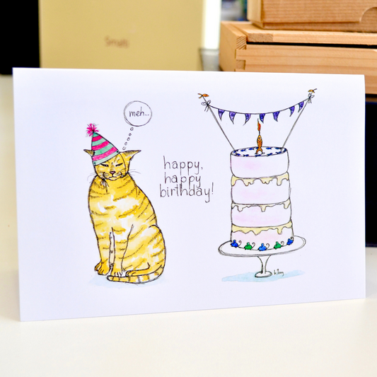 A ginger cat wearing a birthday hat thinking "Meh". There is a birthday cake decorated with a fish candle and mice. The text reads "Happy, happy birthday!".