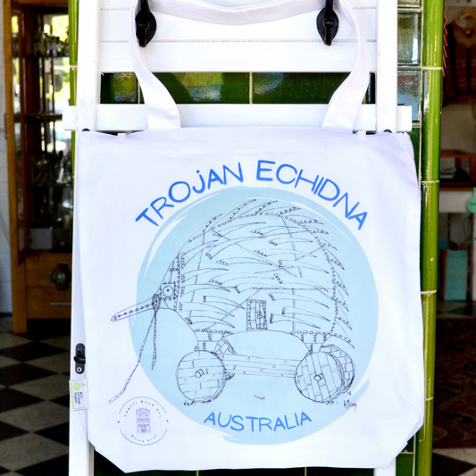 A humorous artwork of a Trojan Echidna from original artwork by Helen Gray. Black ink drawing on a green circular background, printed on white cotton, with blue writing that says Trojan Echidna Australia, above and below the drawing. The size is 40x40cm.