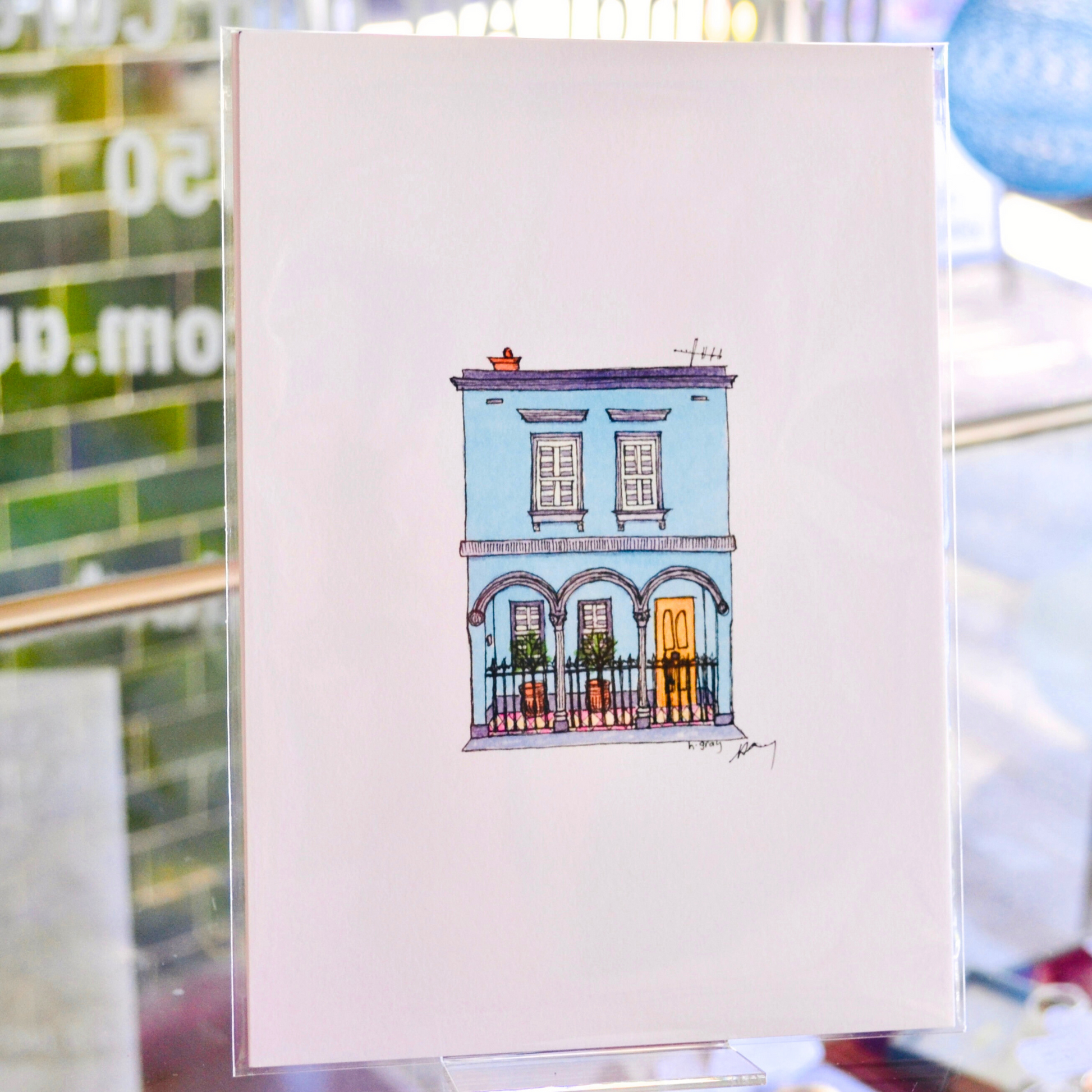 Aqua Australian terrace house with a yellow door and grey trim, and potted plants on the verandah. Printed on watercolour paper with artist pigment, signed and ready for framing.